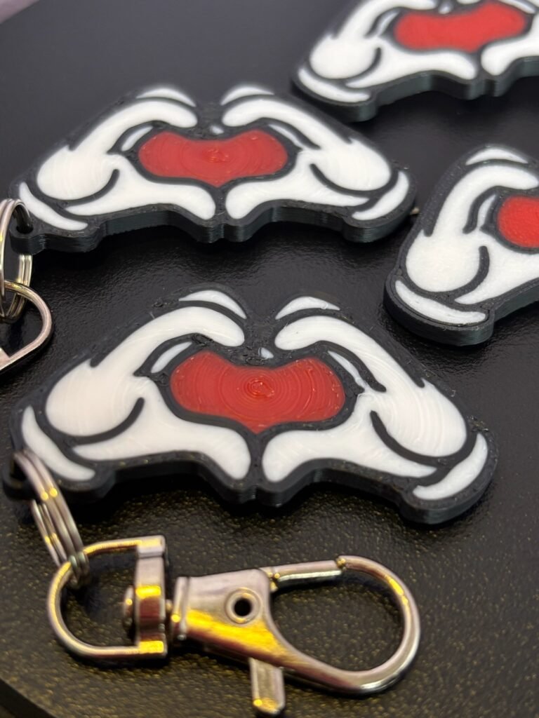 Mickey and Minnie-style 3D printed hand heart keyrings in white PLA with bow and heart detail variations