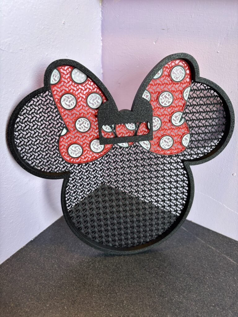 3D printed Minnie pin board with bow design in black and red PLA for displaying enamel pins