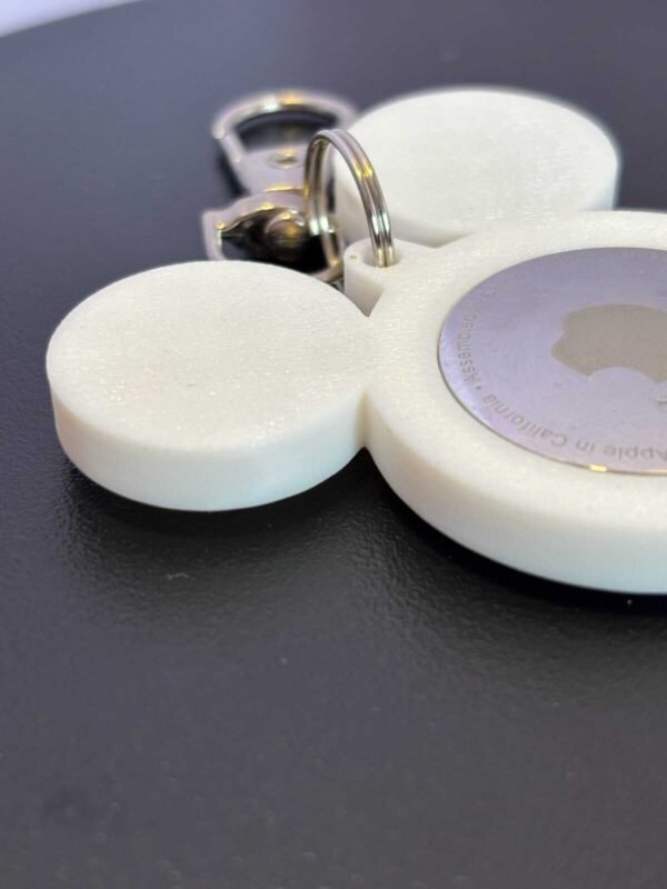 Front-facing white mouse-ear AirTag bag charm with attached metal clasp