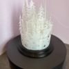 Festive lantern with layered snowy forest and cabin design