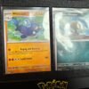 Black 3D-printed Pokémon card display frame holding two sleeved cards