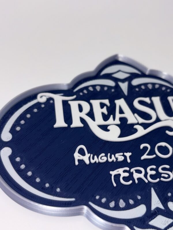 Personalised magical cruise Treasure door plaque magnet — navy blue quatrefoil shaped stateroom sign with silver ornate frame, showing ship name, date and personalised name in raised white text, UK 3D printed