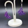 Pair of purple-blue silk geometric low-poly butterfly dangle earrings on display stand - 3D printed EcoPlastic jewellery by HulkyWears UK