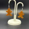 Pair of gingerbread man dangle earrings on display stand - 3D printed EcoPlastic festive Christmas jewellery by HulkyWears UK
