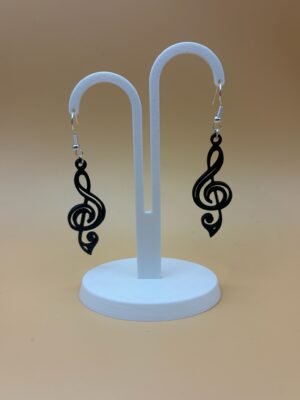 Pair of black treble clef dangle earrings on display stand - 3D printed music jewellery by HulkyWears UK