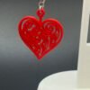 Pair of red filigree heart dangle earrings on display stand - 3D printed romantic jewellery by HulkyWears UK