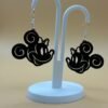 Pair of black magic bow mouse dangle earrings on display stand - 3D printed EcoPlastic fan jewellery by HulkyWears UK