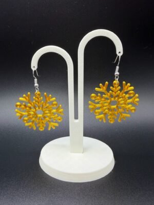 Pair of golden yellow snowflake dangle earrings on display stand - 3D printed EcoPlastic festive jewellery by HulkyWears UK