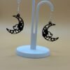 Pair of black crescent moon filigree heart star dangle earrings on display stand - 3D printed EcoPlastic celestial jewellery by HulkyWears UK