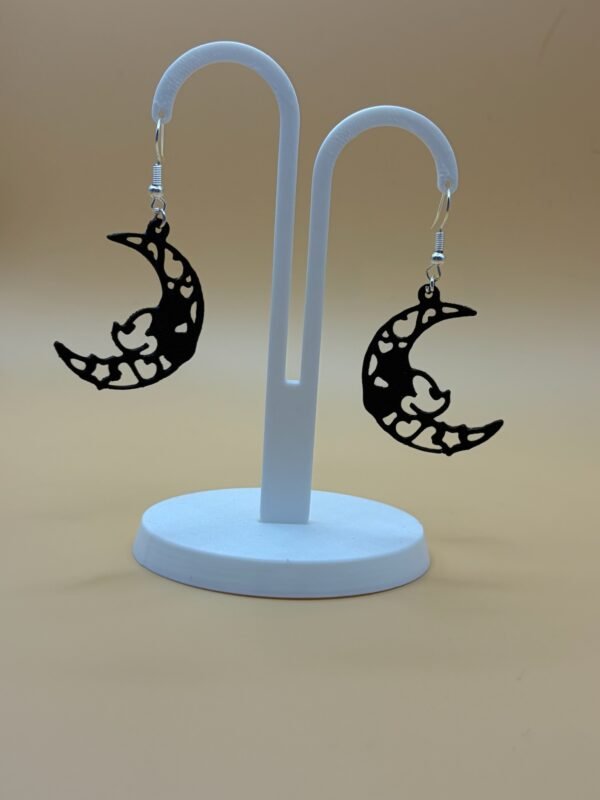 Pair of black crescent moon filigree heart star dangle earrings on display stand - 3D printed EcoPlastic celestial jewellery by HulkyWears UK