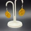 Pair of gold snowflake disc dangle earrings on display stand - 3D printed festive jewellery by HulkyWears UK