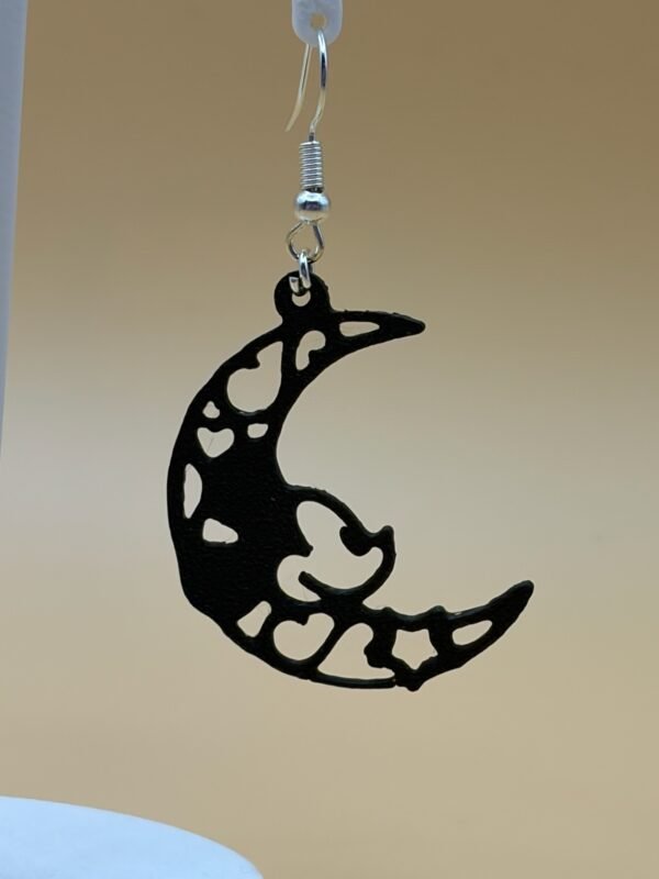Close-up of black crescent moon dangle earring showing filigree heart and star cutout detail - HulkyWears 3D printed jewellery UK