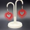 Pair of red sunburst heart dangle earrings on display stand - 3D printed romantic jewellery by HulkyWears UK