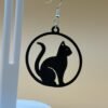 Close-up of black solid cat silhouette in circular disc dangle earring with silver hypoallergenic hook - HulkyWears 3D printed jewellery