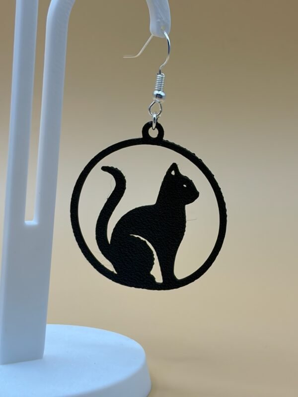 Close-up of black solid cat silhouette in circular disc dangle earring with silver hypoallergenic hook - HulkyWears 3D printed jewellery