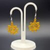 Pair of golden yellow spiral sun dangle earrings on display stand - 3D printed boho jewellery by HulkyWears UK