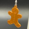Close-up of gingerbread man dangle earring showing embossed smile, buttons and icing detail - HulkyWears 3D printed Christmas jewellery