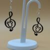Pair of black Mickey treble clef dangle earrings on display stand - 3D printed music and magic fan jewellery by HulkyWears UK