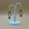 Pair of black cat silhouette dangle earrings with spiral tail on display stand - 3D printed EcoPlastic jewellery by HulkyWears UK