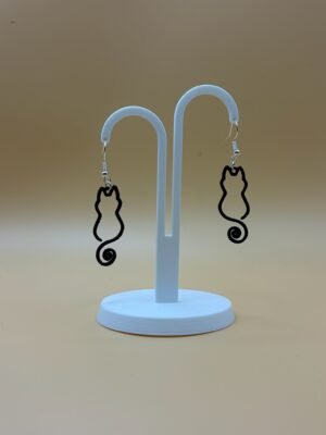 Pair of black cat silhouette dangle earrings with spiral tail on display stand - 3D printed EcoPlastic jewellery by HulkyWears UK