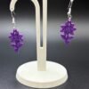 Pair of purple filigree flower dangle earrings on display stand - 3D printed boho jewellery by HulkyWears UK