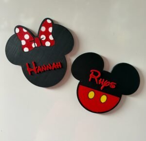 Personalised enchanted mouse head character magnet plaques — boy mouse with red costume and yellow buttons personalised with Rhys, and girl mouse with red sparkle polka dot bow personalised with Hannah, 3D printed UK