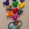 up house & balloons Rainbow Mickey balloon magnets arranged like the Up house balloons on a magnetic surface with a small Up house Mickey magnet below