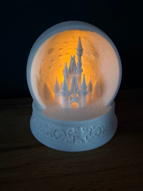 img 9526 Light up Cinderella Castle snow globe – white 3D printed Magic Kingdom castle inside a bauble with snowflakes and trees, glowing with a warm LED tea light on an ornate star base